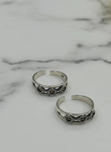 Two silver rings with decorative elements on a marble surface