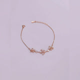 Rose gold bracelet with floral designs on a light purple background