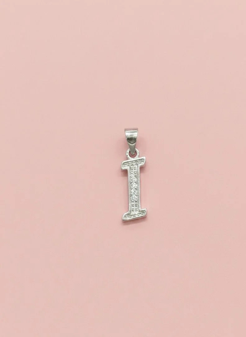Silver letter 'I' pendant with small diamonds on a pink background