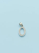 Silver pendant with intricate design on a light blue background