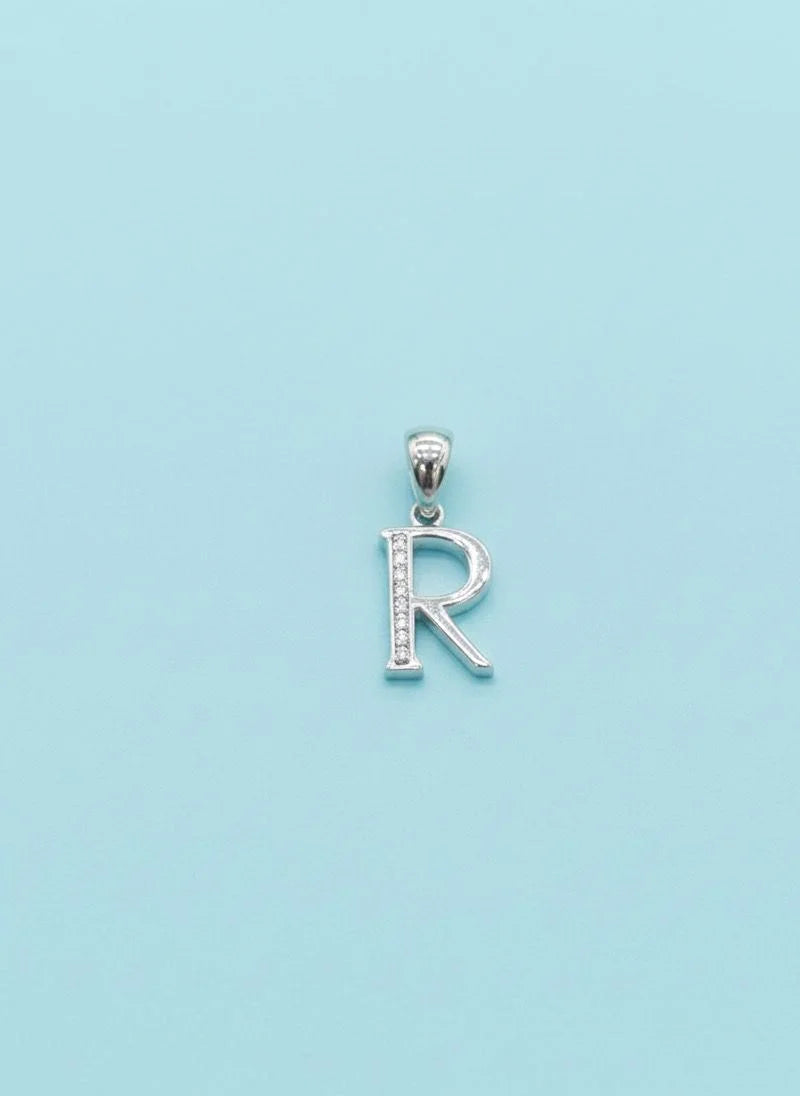 Silver 'R' pendant on a light blue background