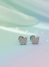 Butterfly-shaped earrings with gemstones on a gradient background