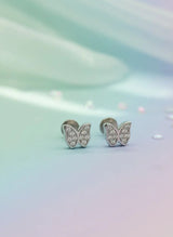 Butterfly-shaped earrings with gemstones on a gradient background