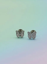 Butterfly-shaped earrings with gemstones on a gradient background