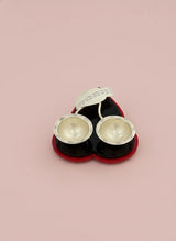 Pair of silver earrings in a black and red box on a pink background