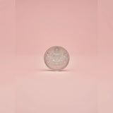 Silver coin with Lakshmifigure on a pink background