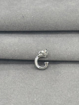 Silver pendant on a gray fabric background