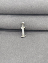 Silver letter 'I' pendant on a gray fabric background