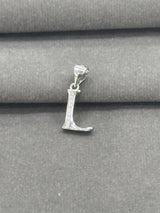 Silver 'L' pendant on a gray fabric background