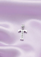 Silver 'T' pendant with small stones on a pink satin background