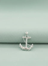 Silver anchor pendant on a light green background
