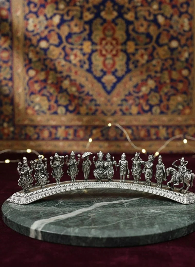 Silver diorama of figures on a marble base with a patterned rug in the background