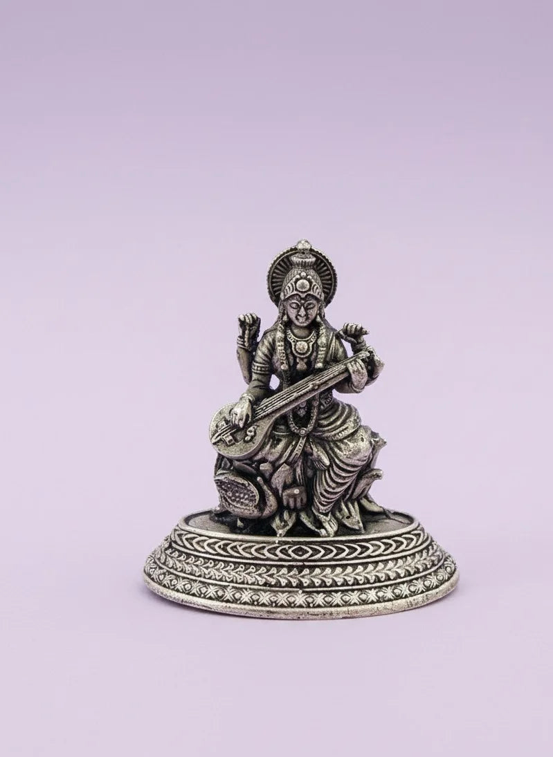 Statue of a seated figure playing a stringed instrument on a light purple background