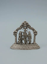 Decorative silver emblem with three figures on a gray background