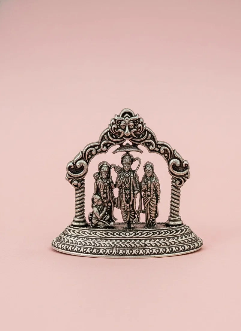 Decorative metal piece with figures on a pink background