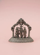 Decorative metal piece with figures on a pink background