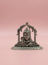 Decorative metal statue of a deity on a pink background