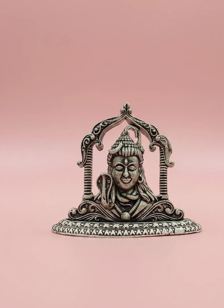 Decorative metal statue of a deity on a pink background