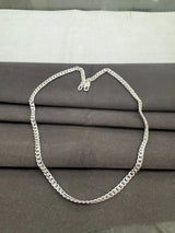 Silver chain necklace on a gray fabric background