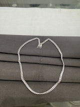 Silver chain necklace on a gray surface