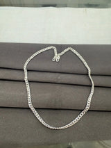 Silver chain necklace on a gray surface