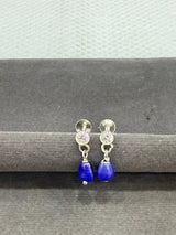 Pair of earrings with blue teardrop stones on a gray background