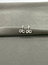 Silver infinity symbol earrings on a gray surface