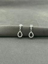 Pair of silver teardrop earrings on a gray surface