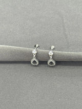 Pair of silver earrings with gemstones on a gray background