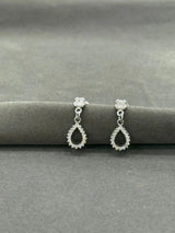 Pair of silver teardrop earrings on a gray surface