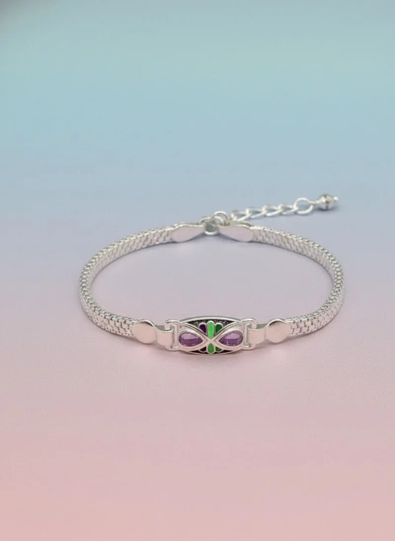 Silver bracelet with a green and purple gemstone on a gradient background