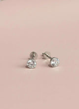 Pair of stone stud earrings on a pink background
