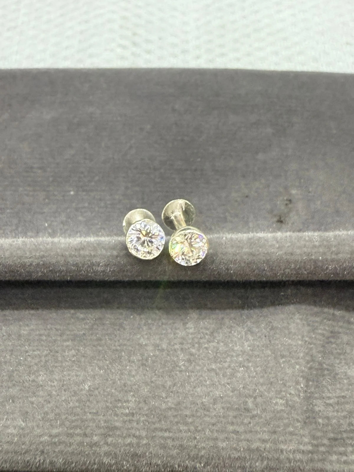 Pair of  stud earrings on a gray surface