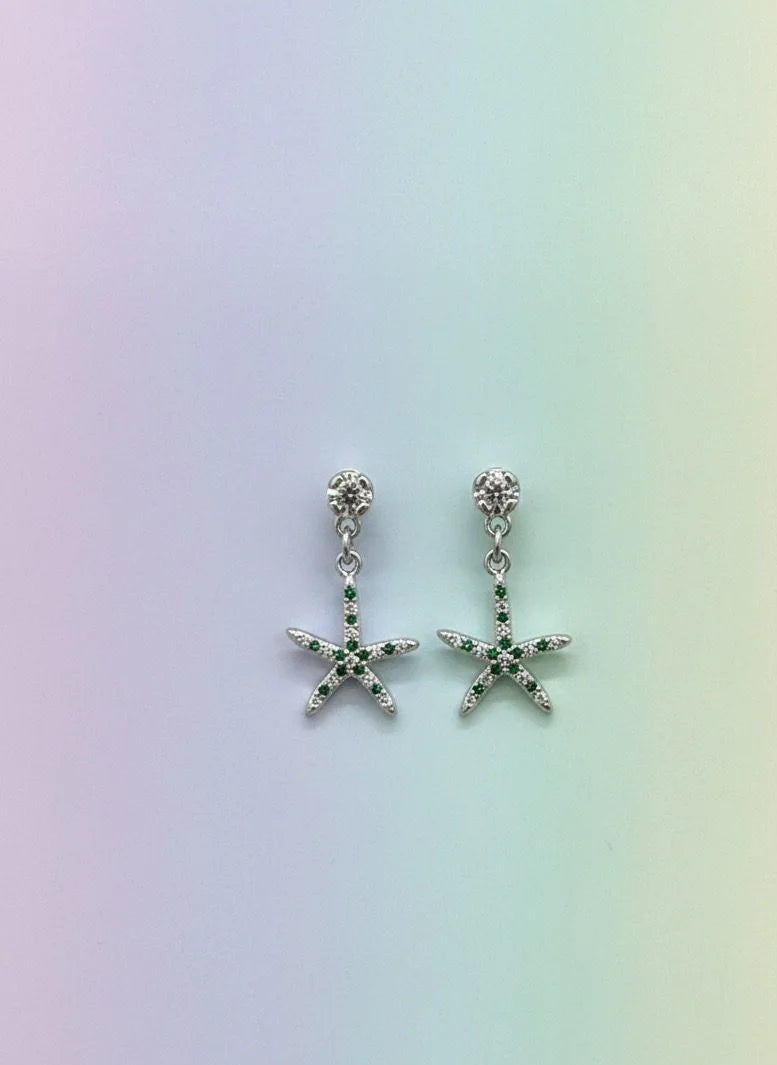 Starfish-shaped earrings on a gradient background