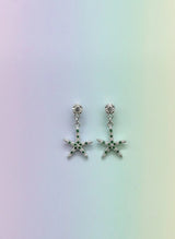 Starfish-shaped earrings on a gradient background