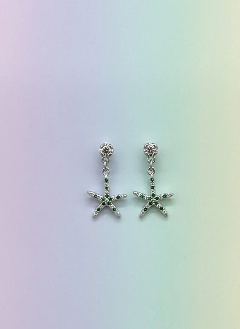 Starfish-shaped earrings on a gradient background