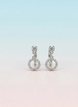 Pair of silver earrings with circular designs on a gradient background