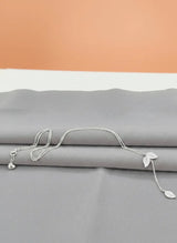 925 Silver necklace with leaf pendants on a gray surface with an orange background