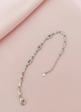 Silver bracelet with pink gemstones on a pink background
