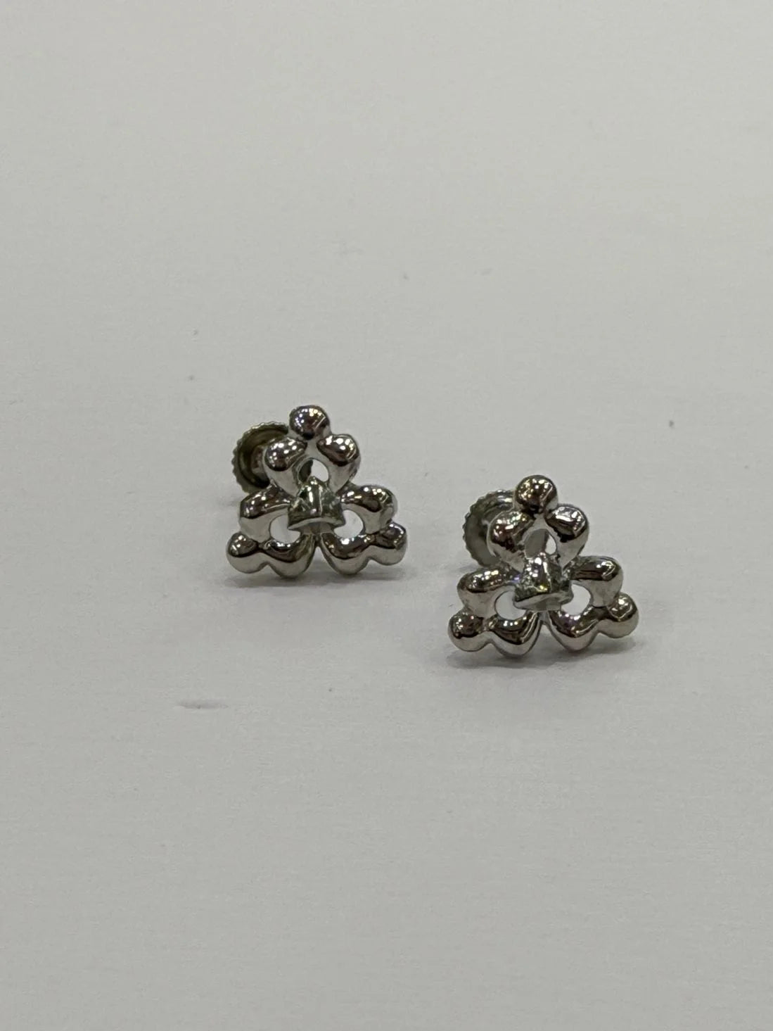 Pair of silver floral earrings on a light gray background