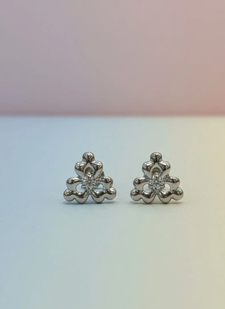 Pair of silver flower-shaped earrings on a gradient background