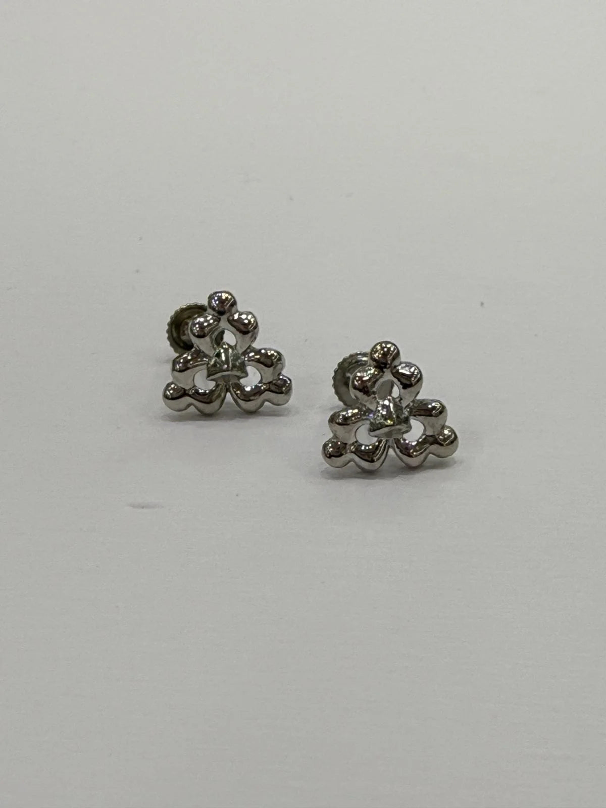 Pair of silver floral earrings on a light gray background