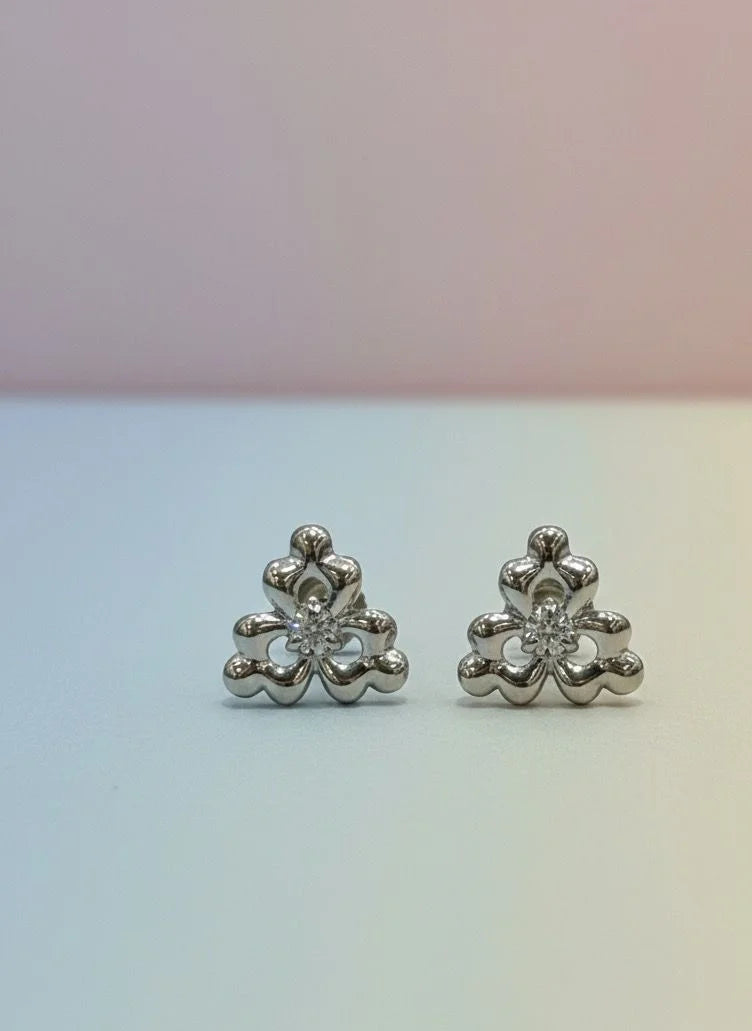 Pair of silver floral earrings on a gradient background