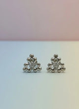 Pair of silver floral earrings on a gradient background