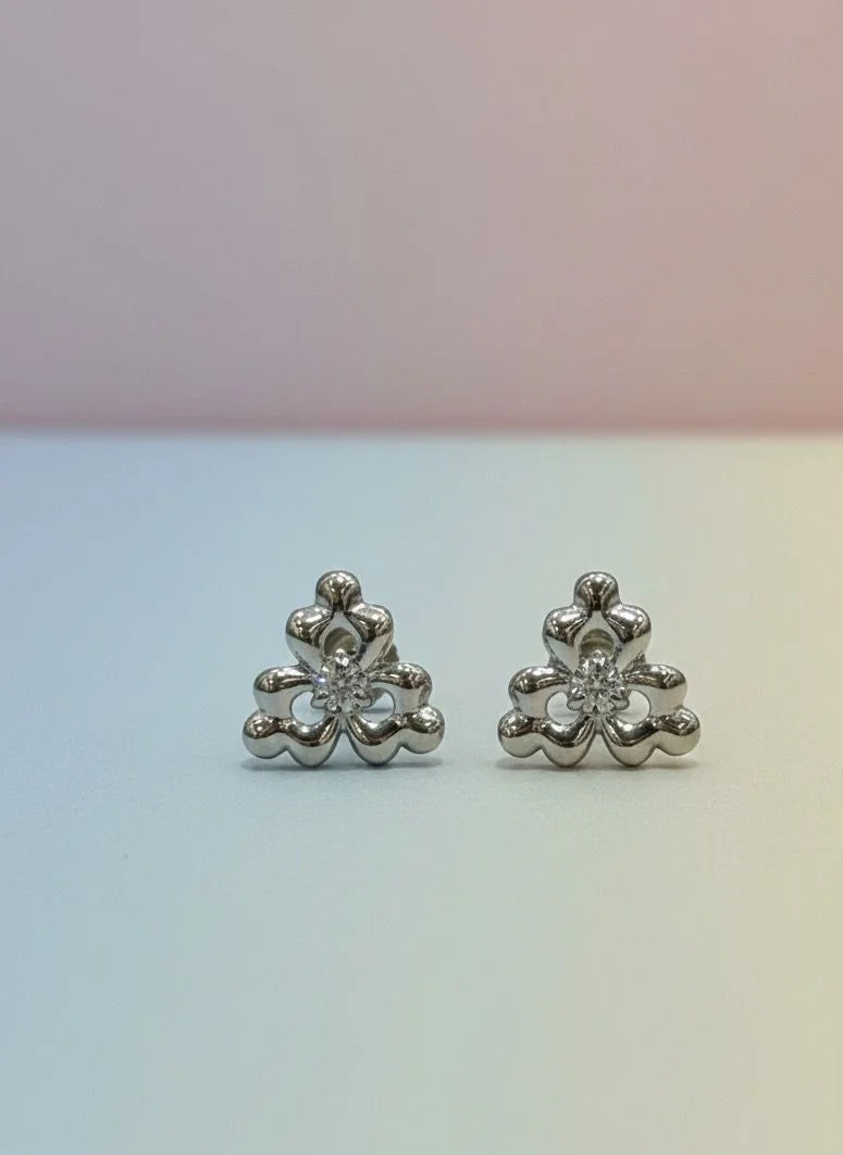 Pair of silver floral earrings on a gradient background