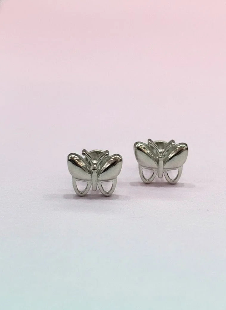 Butterfly-shaped silver earrings on a gradient pink and blue background