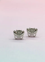 Butterfly-shaped silver earrings on a gradient pink and blue background