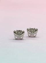 Butterfly-shaped silver earrings on a gradient pink and blue background