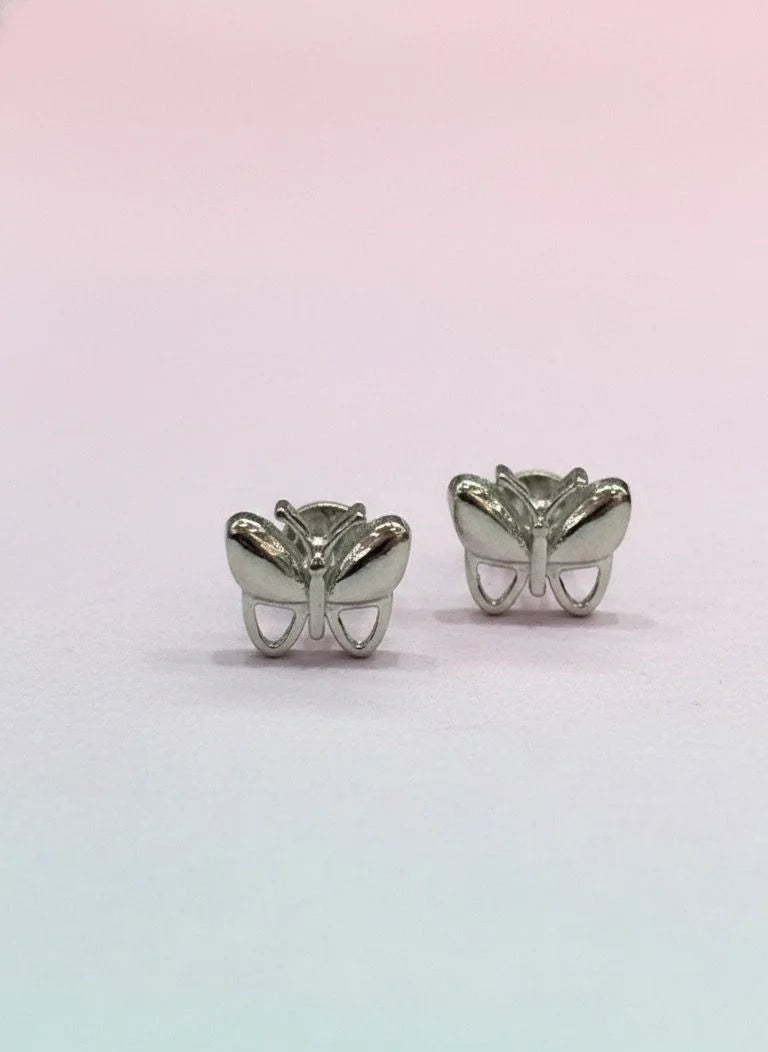 Butterfly-shaped silver earrings on a gradient pink and blue background