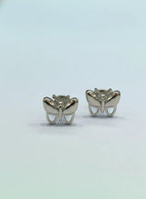 Butterfly-shaped silver earrings on a light gray background